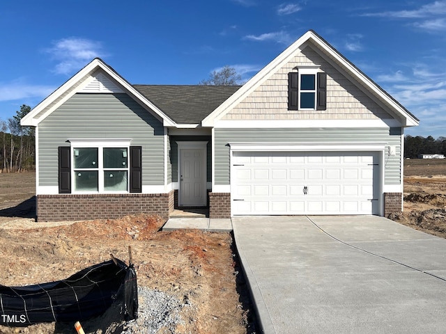 view of front of home with driveway and brick siding