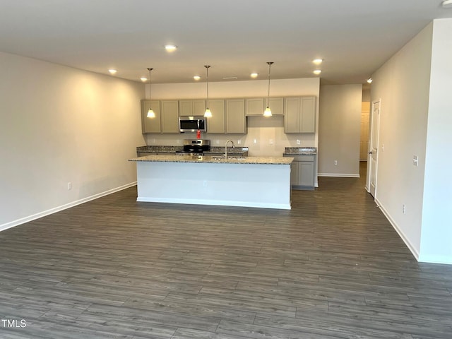 kitchen with recessed lighting, stainless steel appliances, a sink, gray cabinets, and dark wood finished floors