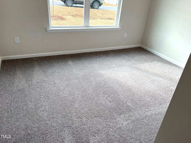 carpeted empty room with baseboards