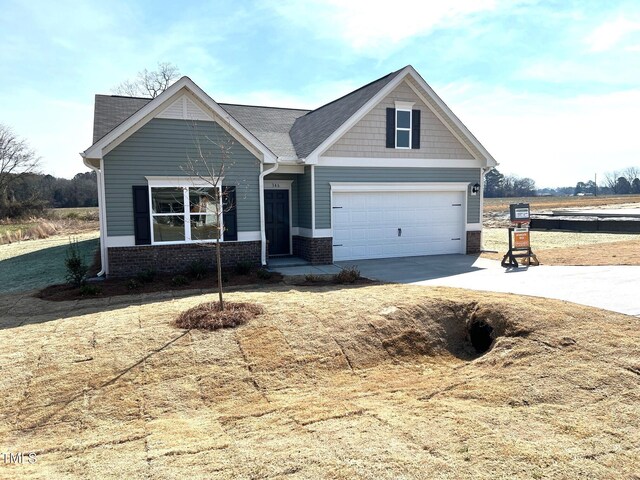 craftsman-style home with a garage, brick siding, and driveway