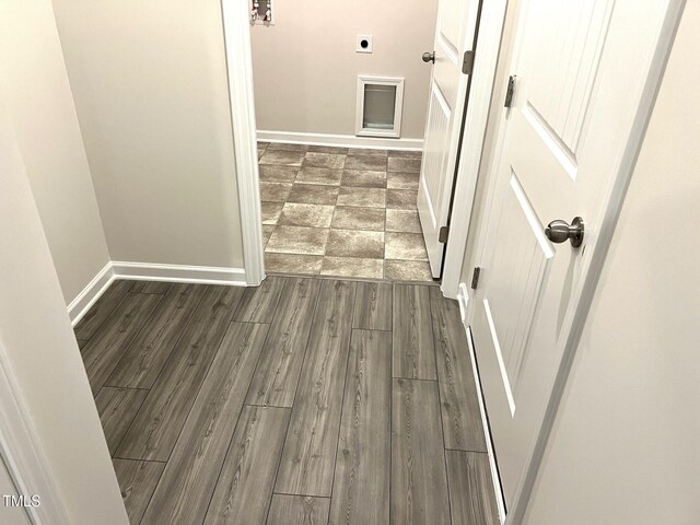 hall with baseboards and wood finished floors