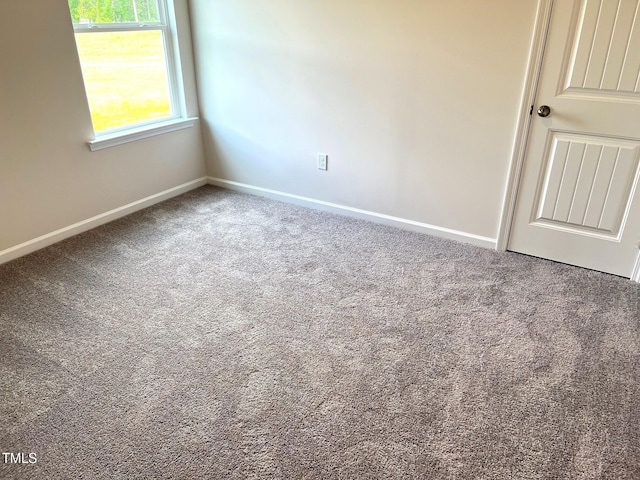 carpeted spare room featuring baseboards