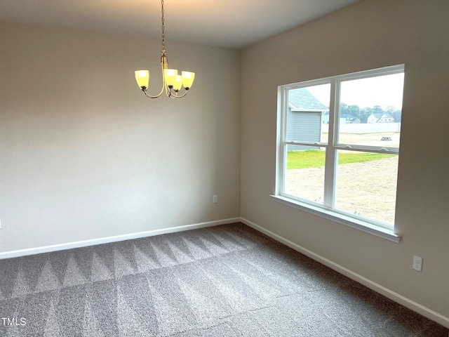 carpeted spare room with a notable chandelier