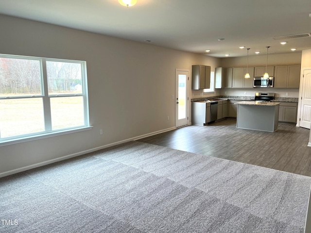 kitchen with pendant lighting, a kitchen island, gray cabinetry, and appliances with stainless steel finishes