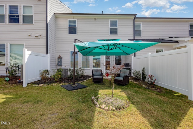 rear view of property featuring an outdoor hangout area, central AC unit, and a lawn