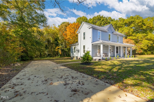 view of property exterior featuring covered porch and a lawn