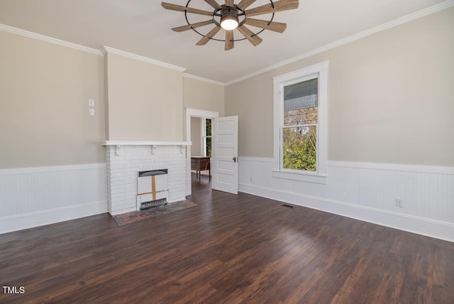 unfurnished living room with ornamental molding, dark hardwood / wood-style floors, ceiling fan, and a brick fireplace