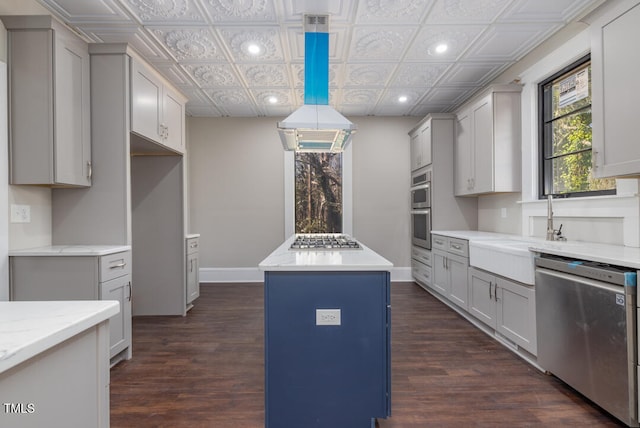 kitchen with appliances with stainless steel finishes, dark hardwood / wood-style floors, a center island, and decorative light fixtures