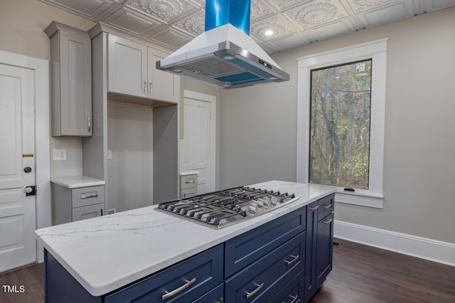 kitchen featuring island range hood, stainless steel gas cooktop, a center island, light stone counters, and dark hardwood / wood-style flooring