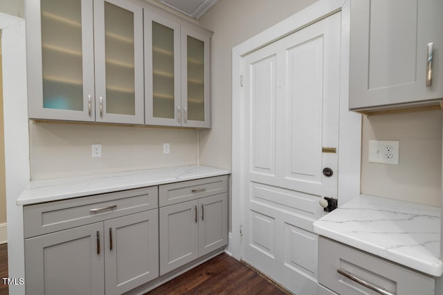 kitchen featuring gray cabinetry, light stone counters, and dark hardwood / wood-style flooring