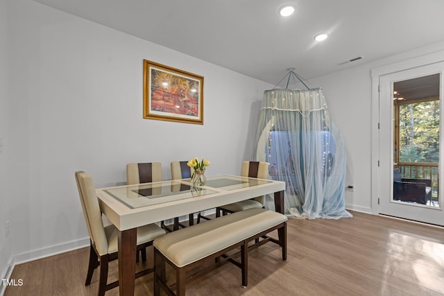 dining area featuring wood-type flooring and an inviting chandelier