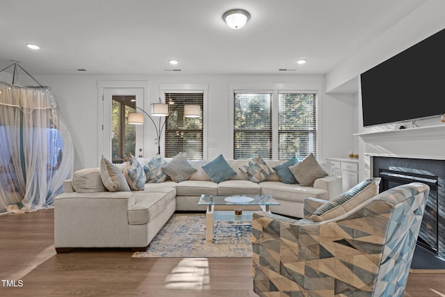 living room with dark wood-type flooring and a tiled fireplace