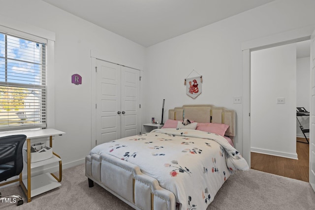 bedroom with light hardwood / wood-style flooring, multiple windows, and a closet