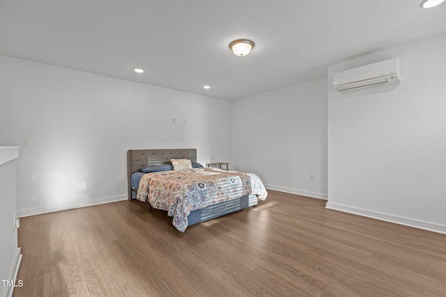 bedroom featuring hardwood / wood-style floors and a wall unit AC