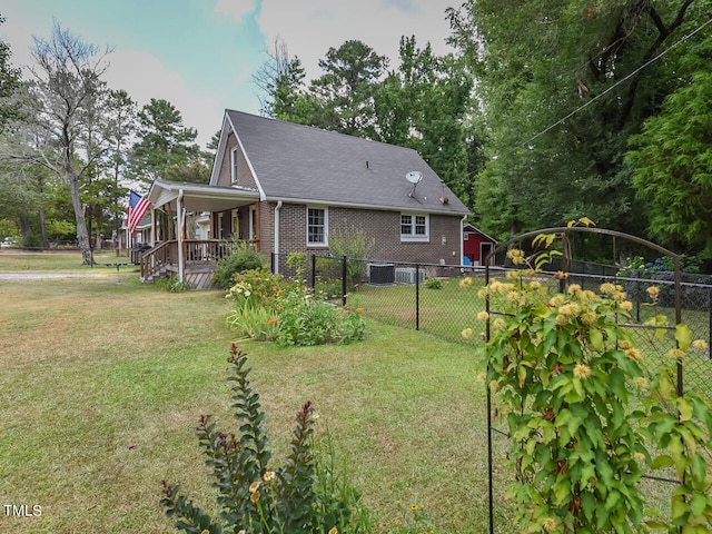 exterior space with a yard, fence, central AC, and brick siding