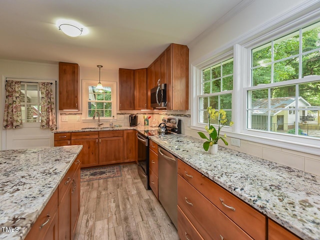 178 Paceville Rd, Selma, NC 27576 - kitchen with stainless steel appliances, a sink, brown cabinets, light wood-style flooring, and decorative backsplash