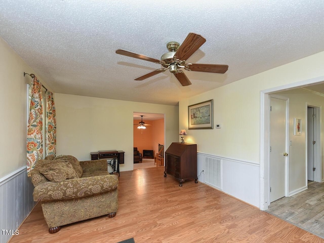 178 Paceville Rd, Selma, NC 27576 - living area with ceiling fan, wainscoting, light wood finished floors, and a textured ceiling