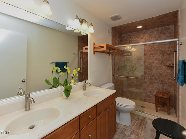 178 Paceville Rd, Selma, NC 27576 - bathroom featuring toilet, double vanity, a tile shower, and wood finished floors