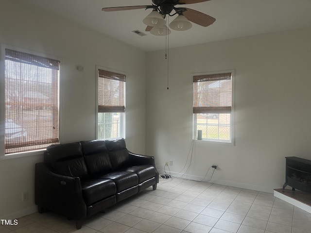 178 Paceville Rd, Selma, NC 27576 - living area featuring ceiling fan, a wood stove, light tile patterned floors, and baseboards
