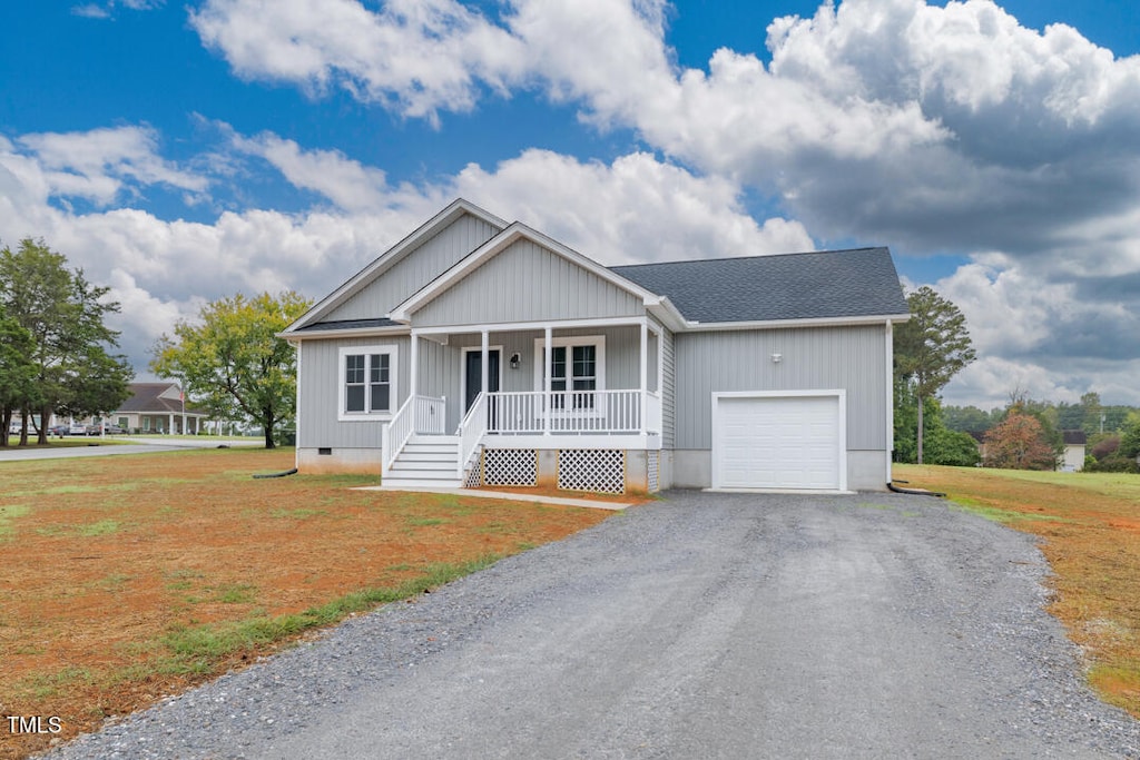 view of front facade with a garage, a porch, and a front yard