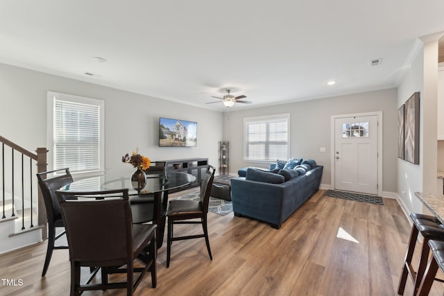 dining room with hardwood / wood-style floors, ceiling fan, and crown molding