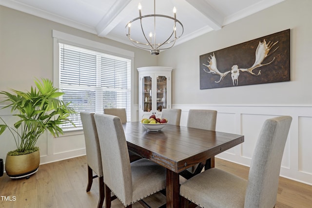 dining space featuring beamed ceiling, wood-type flooring, and crown molding