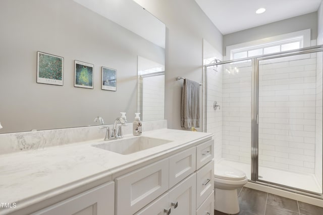 bathroom with vanity, an enclosed shower, and toilet