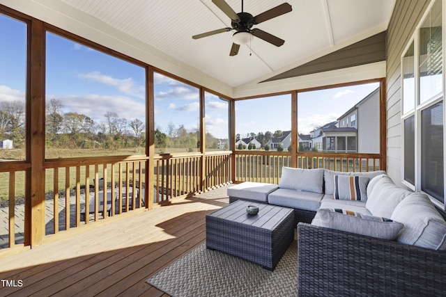 sunroom featuring ceiling fan, a healthy amount of sunlight, and vaulted ceiling