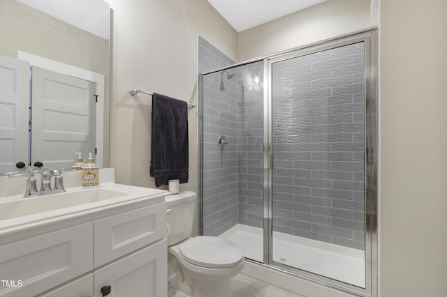 bathroom with vanity, toilet, and a shower with door