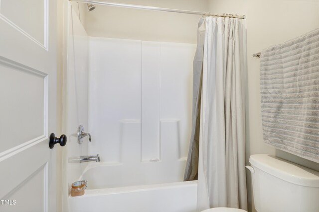 bathroom with toilet and shower / bath combo with shower curtain