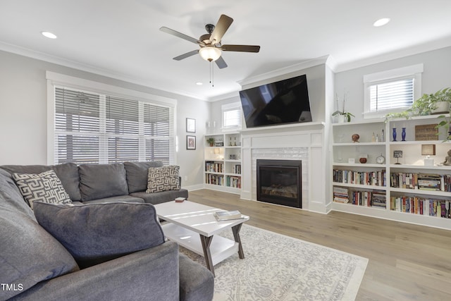 living room with ceiling fan, light wood-type flooring, and ornamental molding