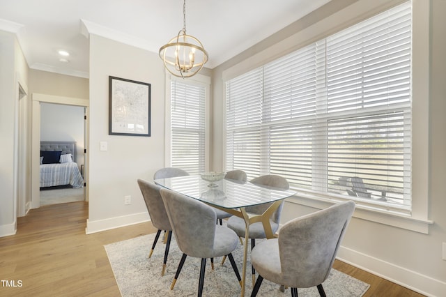 dining space featuring a chandelier, light hardwood / wood-style flooring, a healthy amount of sunlight, and ornamental molding