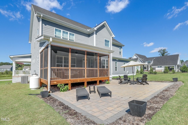 back of house featuring a patio, cooling unit, an outdoor fire pit, a sunroom, and a yard