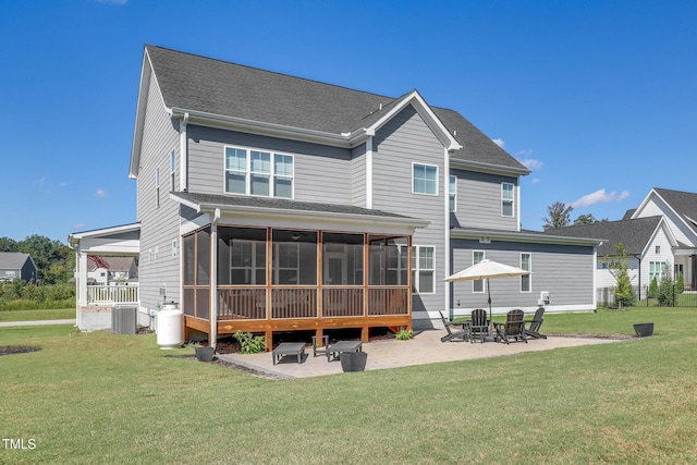 rear view of property with a sunroom, cooling unit, a patio, and a lawn