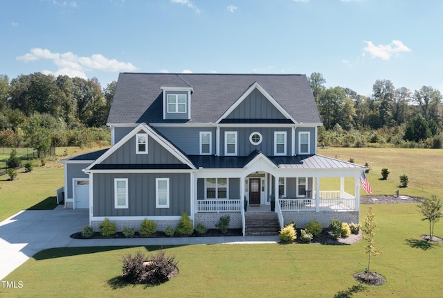 view of front of home featuring a porch, a garage, and a front yard