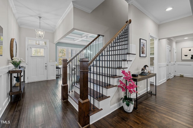 entrance foyer with coffered ceiling, dark hardwood / wood-style floors, crown molding, and a chandelier