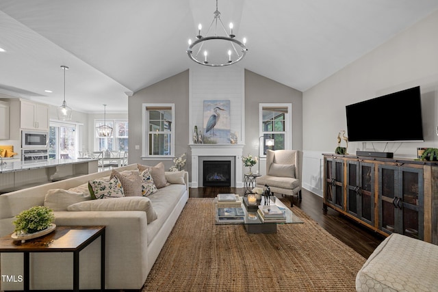 living room with an inviting chandelier, dark hardwood / wood-style flooring, and vaulted ceiling