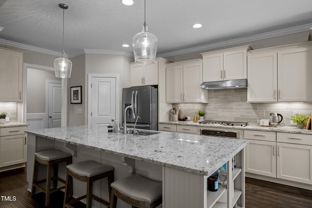 kitchen with pendant lighting, a kitchen island with sink, appliances with stainless steel finishes, and dark wood-type flooring