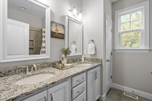 bathroom with curtained shower, tile patterned flooring, and vanity