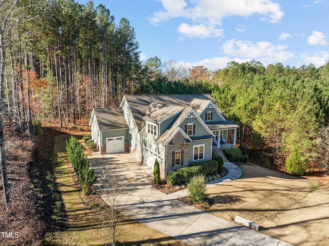 181 Colonial Ridge Dr, Pittsboro, NC 27312 - view of front of property with concrete driveway, a forest view, board and batten siding, and brick siding
