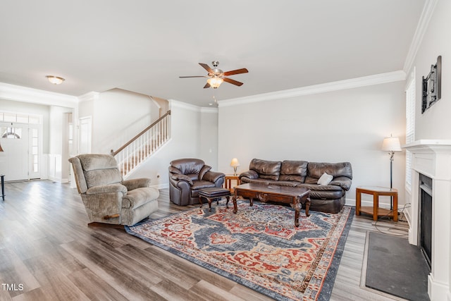 living room featuring hardwood / wood-style floors, ceiling fan, and ornamental molding