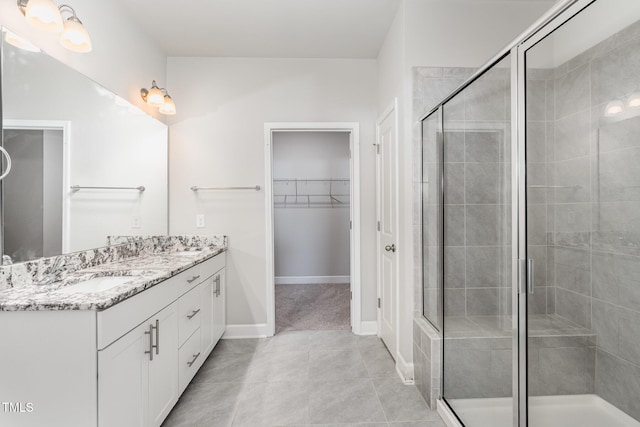 bathroom with tile patterned flooring, vanity, and a shower with shower door