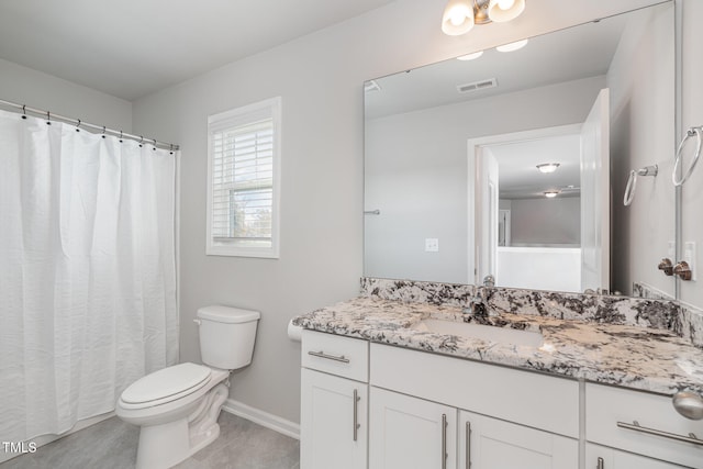 bathroom with toilet, vanity, and tile patterned floors