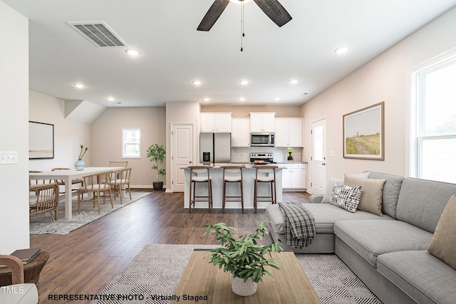 living room with dark hardwood / wood-style floors and ceiling fan