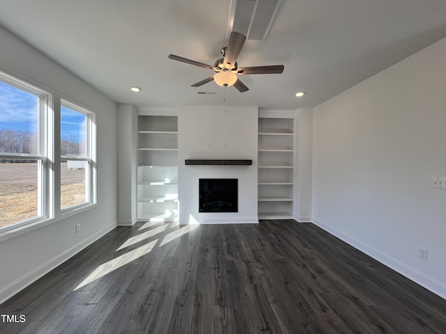 unfurnished living room featuring ceiling fan, dark hardwood / wood-style floors, and built in features