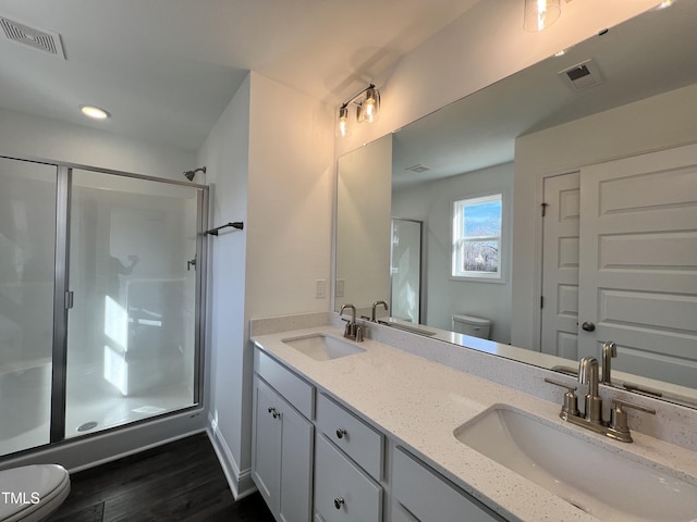 bathroom with walk in shower, vanity, toilet, and wood-type flooring