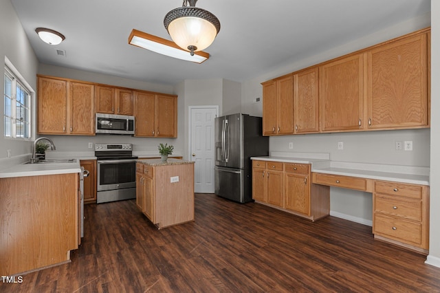 kitchen with stainless steel appliances, dark wood-type flooring, sink, built in desk, and a center island