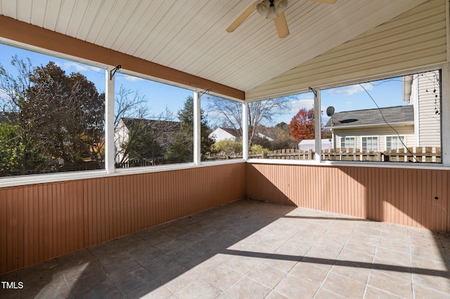 unfurnished sunroom featuring ceiling fan and vaulted ceiling