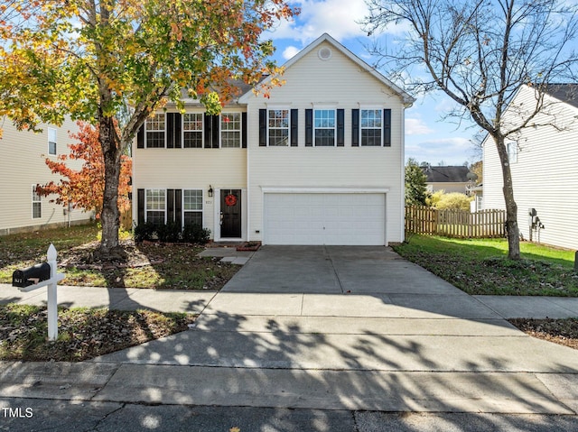 traditional-style house featuring a garage, driveway, and fence