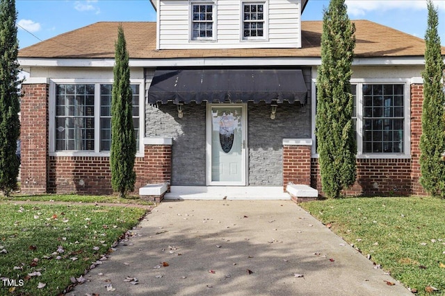 doorway to property with a lawn